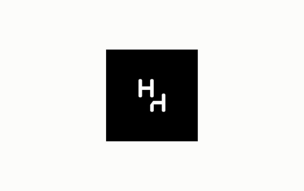 "Minimalist black square logo with two white stylized 'H' letters, one upright and one rotated, creating a mirrored and modern visual identity suitable for a creative or tech brand."